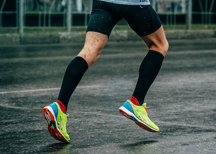 Image of man running featuring his compression therapy socks.