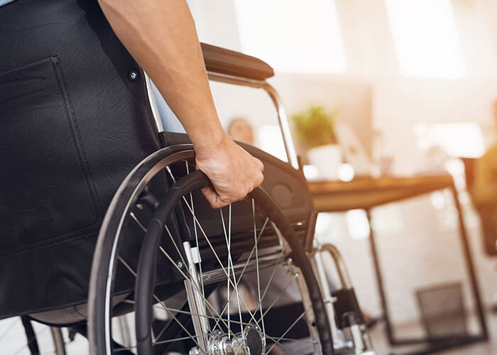 Photo featuring a man in his wheelchair, spinning the wheels.